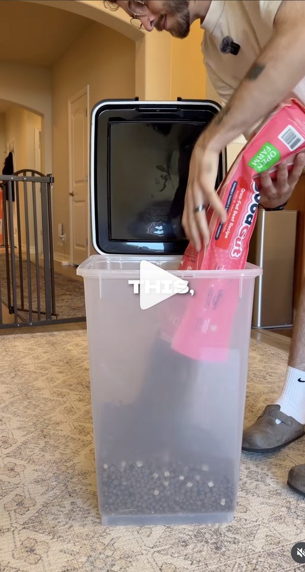 Dumping a new bag of dog food into a storage container